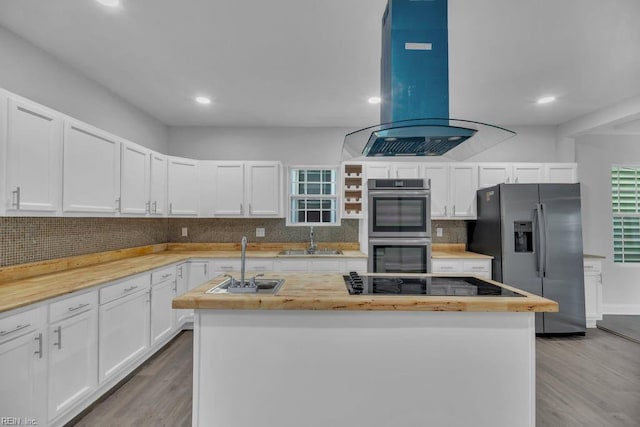 kitchen featuring a sink, a kitchen island, appliances with stainless steel finishes, and island range hood