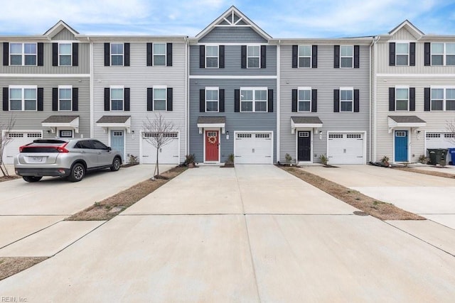 view of property with a garage and driveway