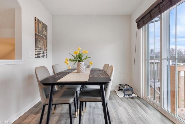 dining area with baseboards and wood finished floors