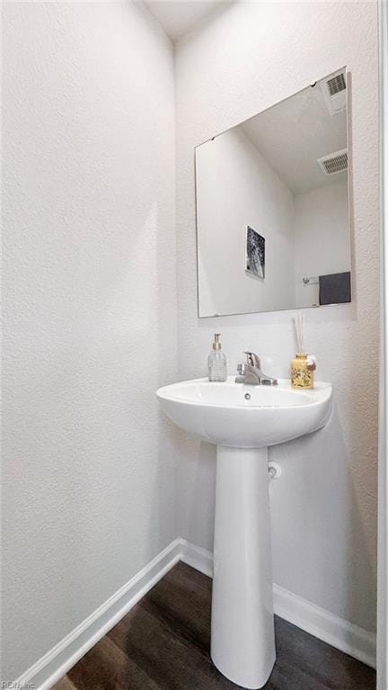 bathroom with visible vents, baseboards, and wood finished floors