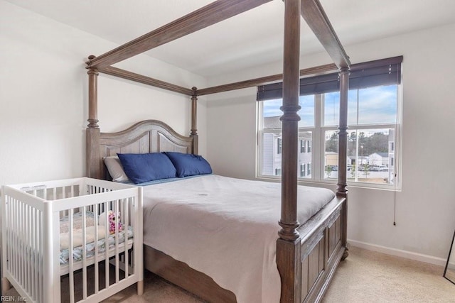 bedroom featuring light colored carpet and baseboards