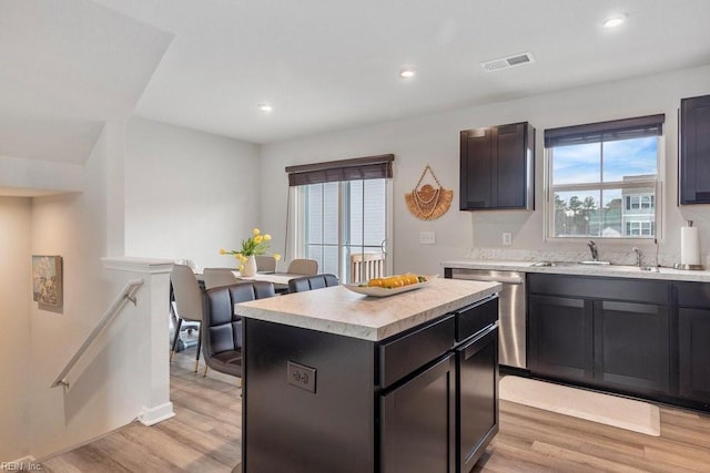 kitchen with dishwasher, light countertops, light wood finished floors, and a center island