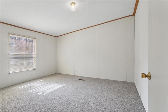 carpeted spare room featuring visible vents and crown molding