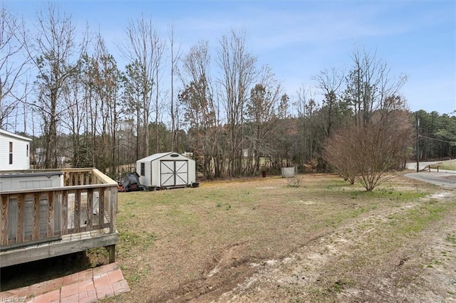 view of yard featuring a deck, an outbuilding, and a shed