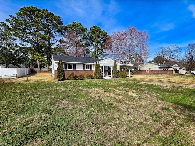 view of front of property with brick siding, a front lawn, and fence