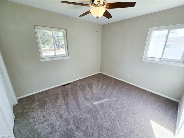 unfurnished room featuring baseboards, visible vents, carpet floors, and ceiling fan