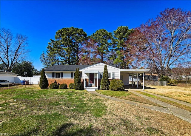 view of front facade with brick siding, an attached carport, a front yard, and fence