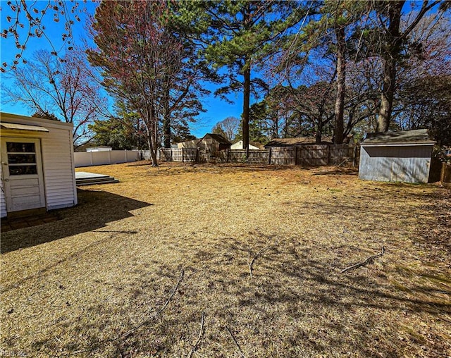 view of yard with a fenced backyard, a storage shed, and an outdoor structure