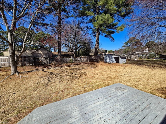 view of yard with a storage shed, an outbuilding, and a fenced backyard