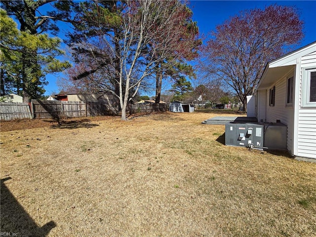 view of yard with an outbuilding, a shed, and fence