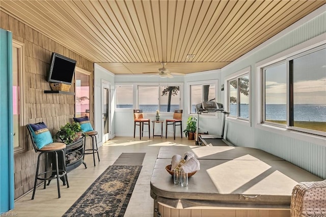 sunroom / solarium with wood ceiling, ceiling fan, and a water view