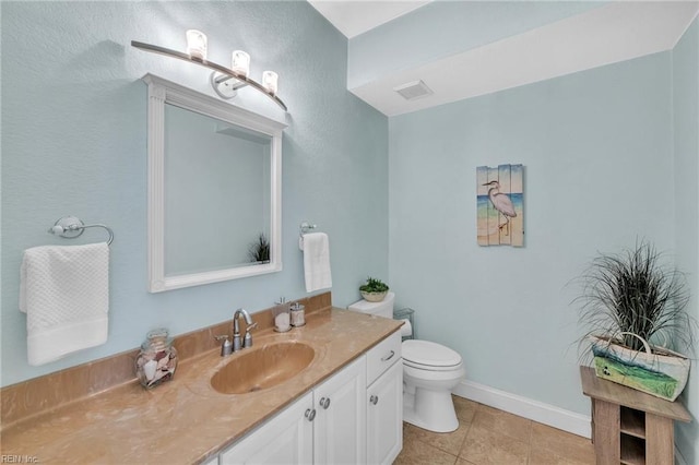 bathroom with vanity, baseboards, visible vents, tile patterned floors, and toilet