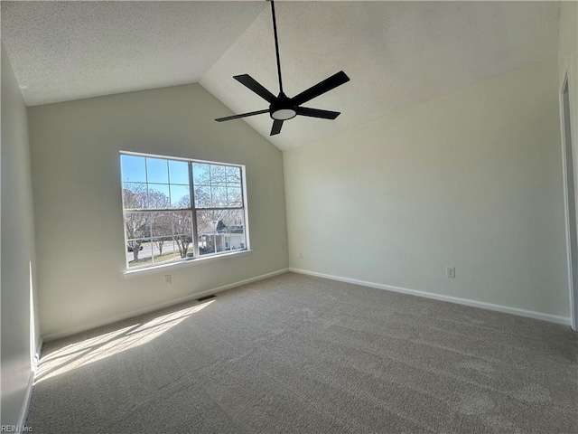 empty room featuring baseboards, ceiling fan, vaulted ceiling, carpet floors, and a textured ceiling