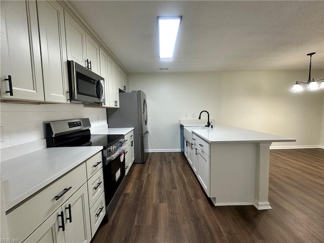 kitchen with tasteful backsplash, a sink, light countertops, stainless steel appliances, and dark wood-style flooring