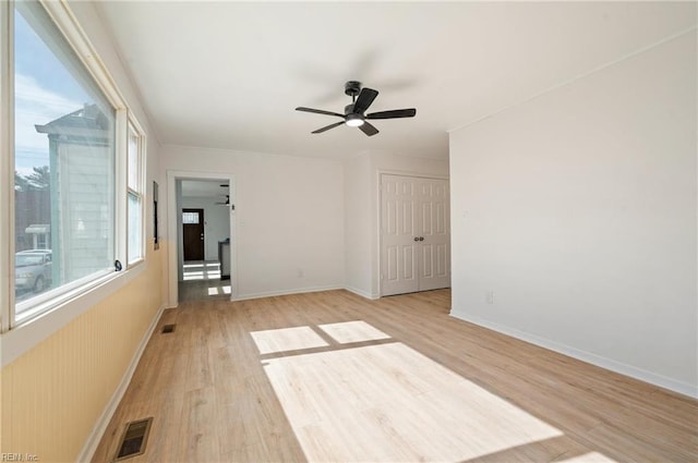 unfurnished room featuring visible vents, ceiling fan, baseboards, and light wood-style floors