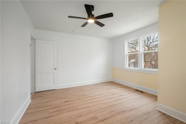 empty room featuring light wood-style floors, visible vents, and baseboards