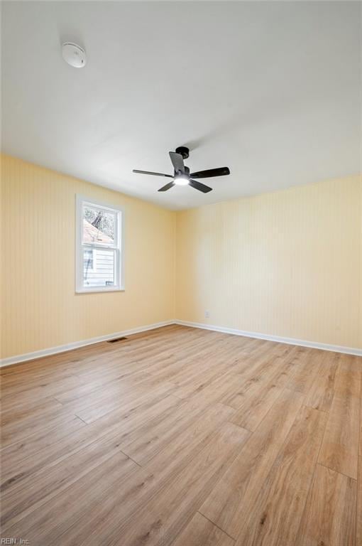 unfurnished room with ceiling fan, baseboards, visible vents, and light wood-type flooring