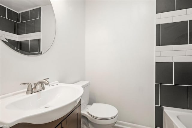 bathroom featuring a tub, baseboards, toilet, and vanity