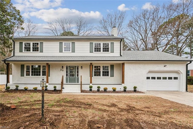 traditional-style house featuring covered porch, a chimney, concrete driveway, a garage, and brick siding