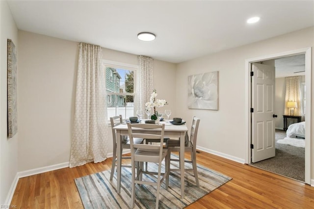 dining space with light wood-style flooring and baseboards