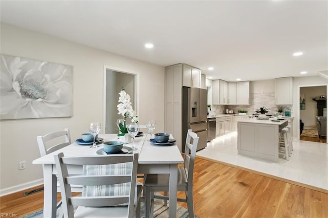 dining room with recessed lighting, light wood-type flooring, baseboards, and visible vents