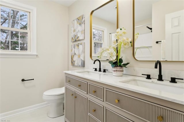 full bath featuring plenty of natural light, toilet, and a sink