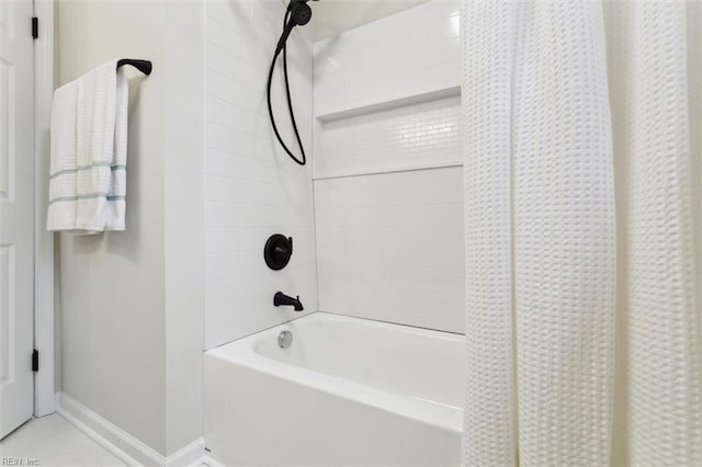 bathroom featuring baseboards and shower / bath combination with curtain