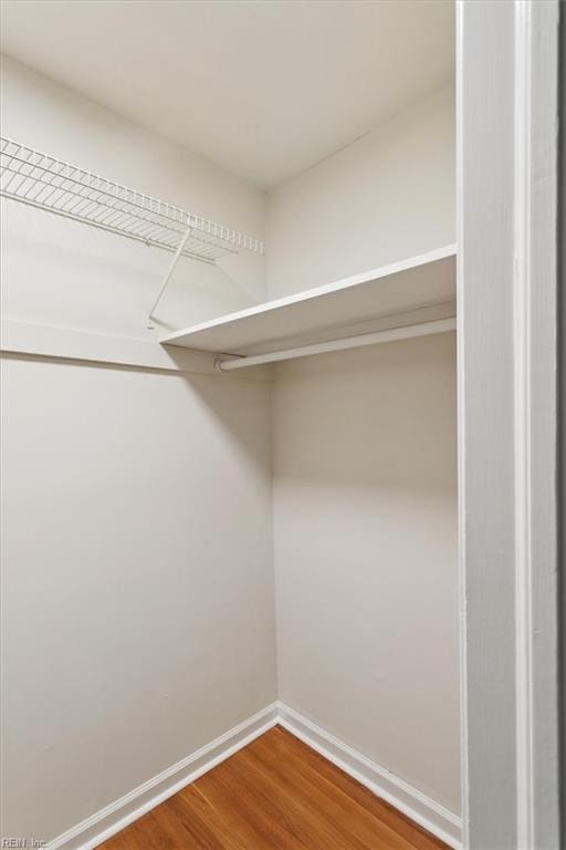 walk in closet with wood finished floors