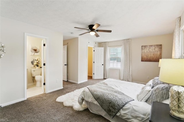 carpeted bedroom featuring baseboards, a textured ceiling, ceiling fan, and ensuite bathroom