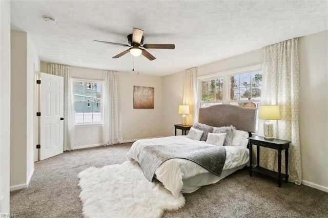 carpeted bedroom featuring ceiling fan, a textured ceiling, and baseboards