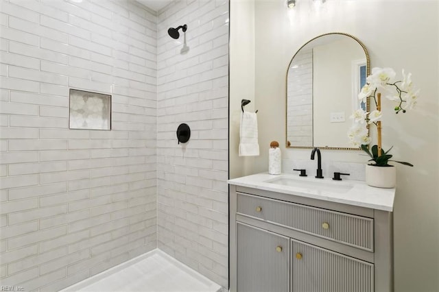 bathroom with vanity and a tile shower