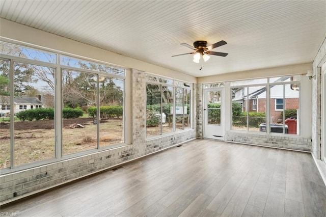 unfurnished sunroom featuring visible vents and ceiling fan