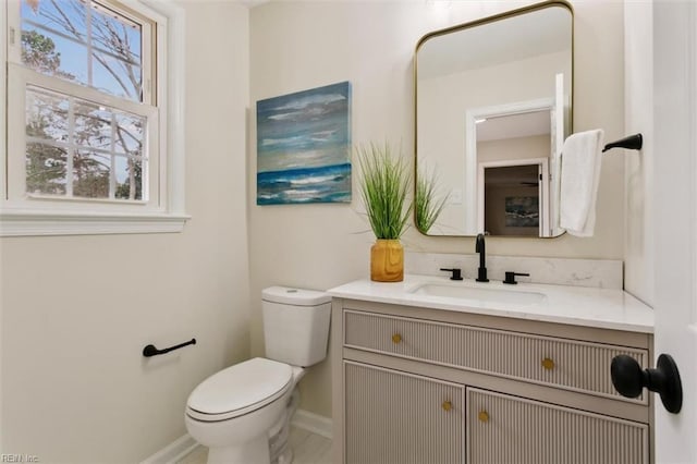 bathroom featuring baseboards, toilet, and vanity