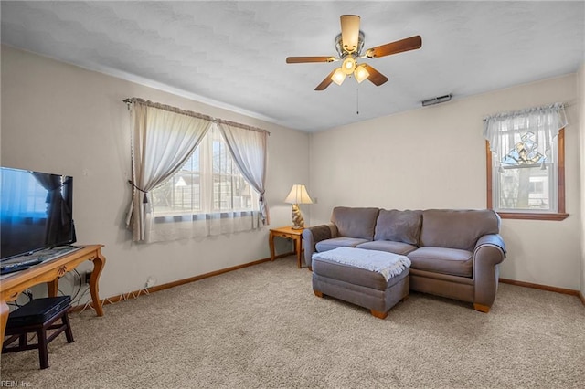 carpeted living area with plenty of natural light, visible vents, baseboards, and a ceiling fan