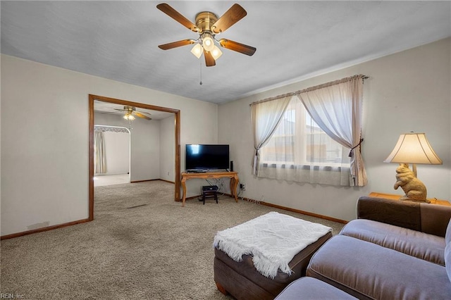 carpeted living room with a ceiling fan and baseboards