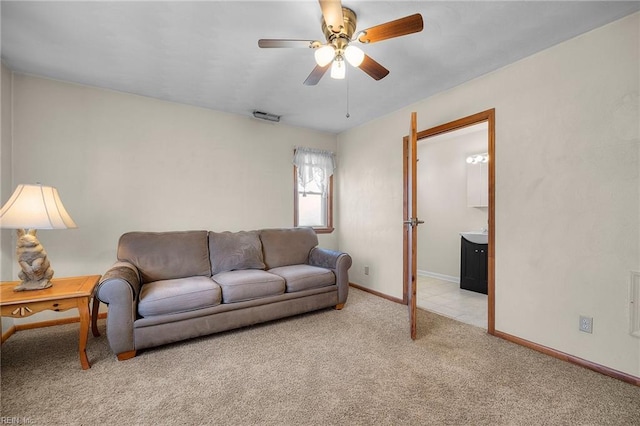 living area with ceiling fan, visible vents, baseboards, and light carpet