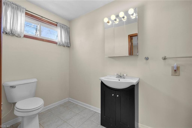 bathroom featuring baseboards, toilet, vanity, and tile patterned flooring