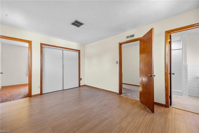 unfurnished bedroom with light wood finished floors, visible vents, and baseboards