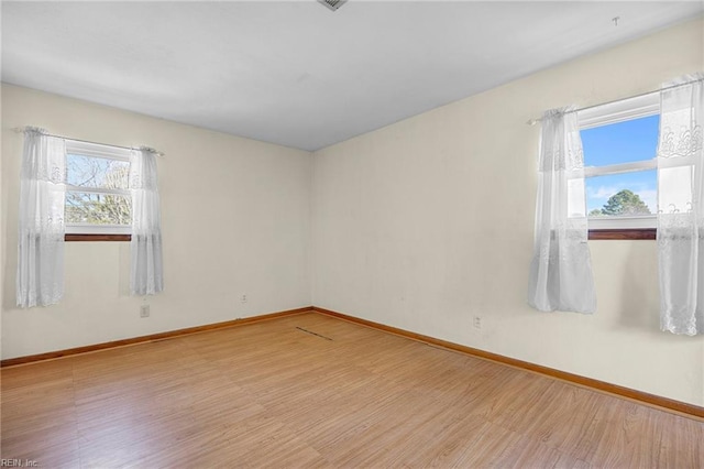 empty room featuring wood finished floors and baseboards