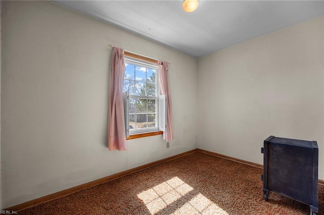 spare room featuring carpet and baseboards