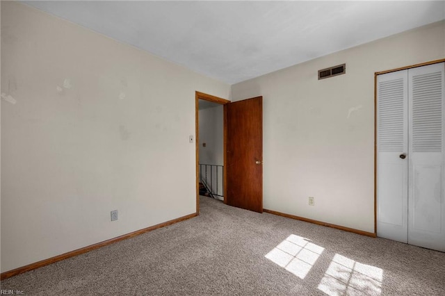 unfurnished bedroom featuring visible vents, baseboards, a closet, and carpet flooring