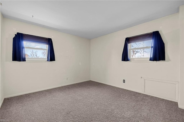 unfurnished room featuring carpet flooring, a healthy amount of sunlight, and baseboards