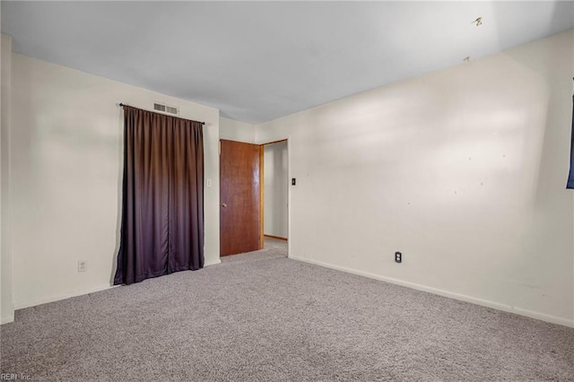 carpeted empty room featuring visible vents and baseboards