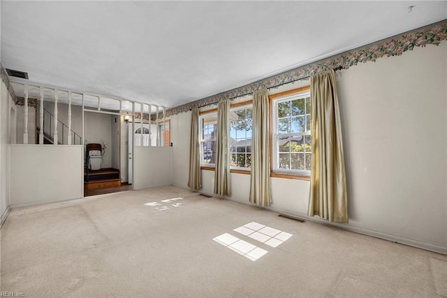 empty room with stairway, carpet flooring, and visible vents