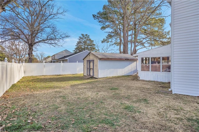 view of yard with a storage shed, a fenced backyard, and an outdoor structure