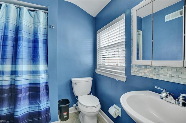 full bath with visible vents, toilet, a sink, curtained shower, and baseboards