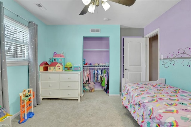 carpeted bedroom featuring a closet, visible vents, baseboards, and ceiling fan