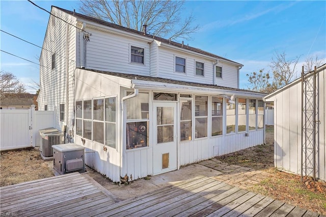 rear view of property featuring a deck, cooling unit, fence, and a sunroom