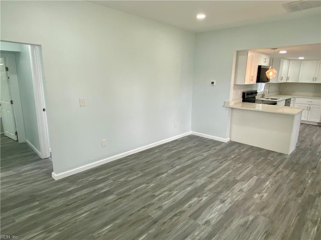 kitchen with visible vents, dark wood-type flooring, range with electric stovetop, light countertops, and baseboards