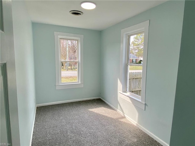 carpeted empty room with visible vents and baseboards